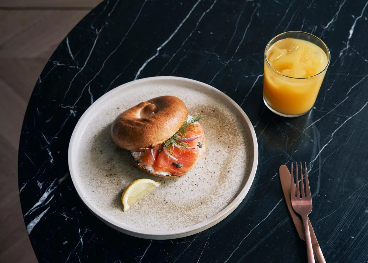 a plate with a sandwich and a glass of orange juice at Page8, Page Hotels in London