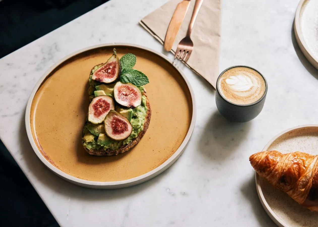 a plate with a sandwich with figs and a cup of coffee at Page8, Page Hotels in London
