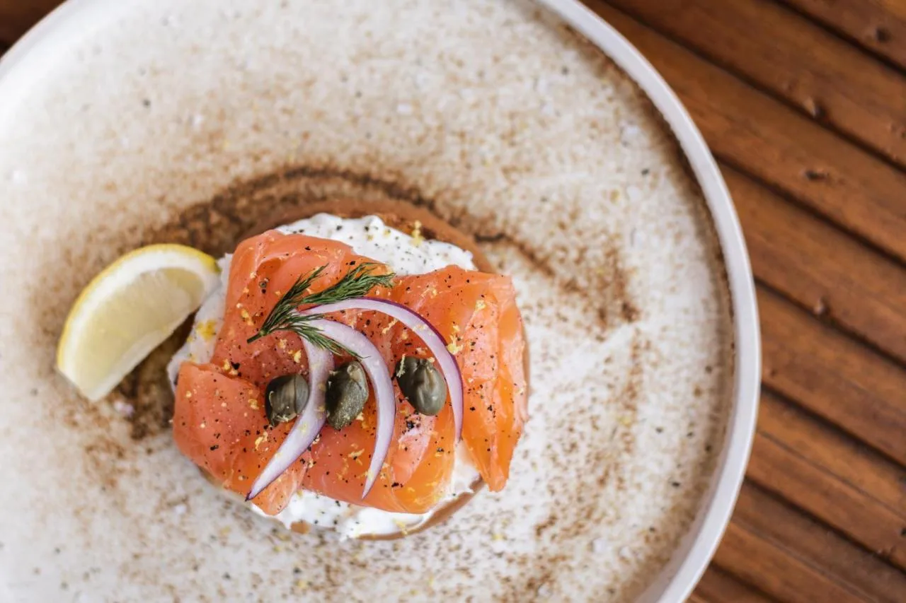 a bowl of food with a piece of salmon and a lemon at Page8, Page Hotels in London
